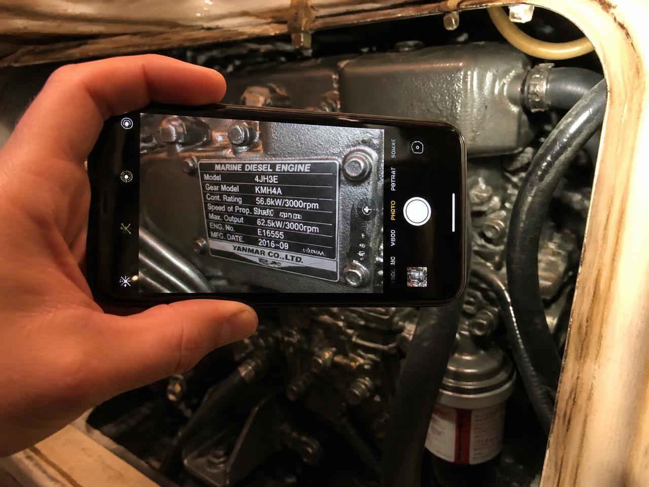 Boat owner photographing the type plate on a marine diesel engine